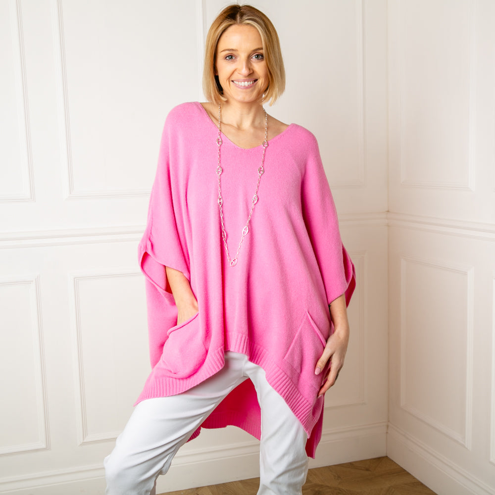 The pink V Neck Pocket Poncho jumper with a v neckline and ribbed detailing along the bottom hemline